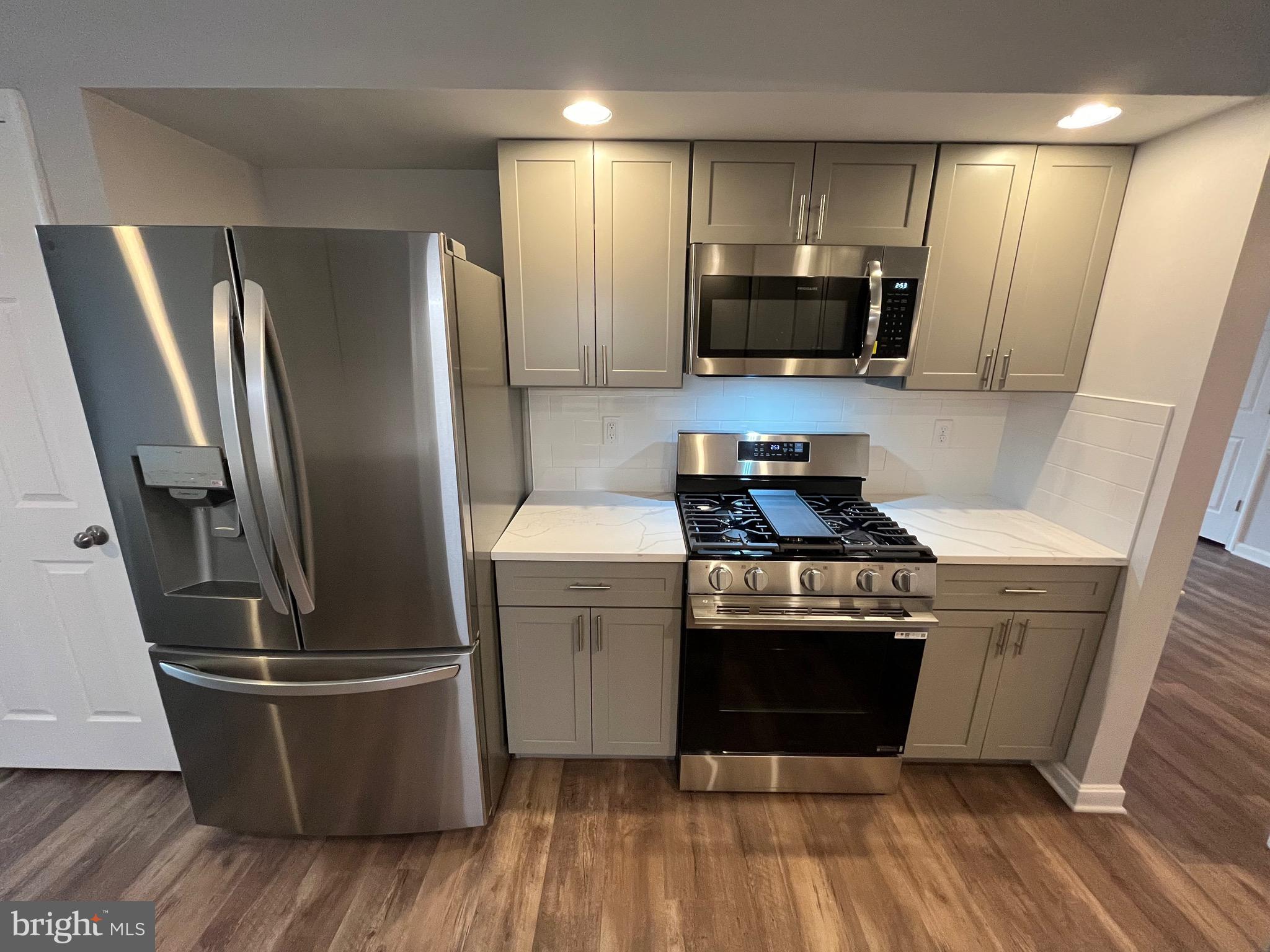 3077 Lakefield Road, Unit 3077 York, PA 17402 - Photo 3 of 33 a kitchen with stainless steel appliances wooden floor sink and wooden cabinets
