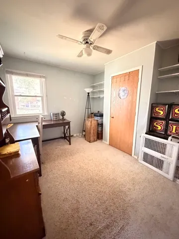 a furnished livingroom with a window and cabinet