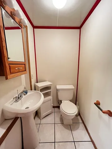 a bathroom with a sink a toilet a mirror and shower