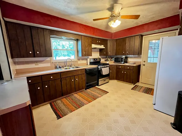 a kitchen with stainless steel appliances granite countertop a sink stove and refrigerator
