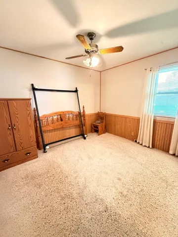 a bed room with a bed and a ceiling fan