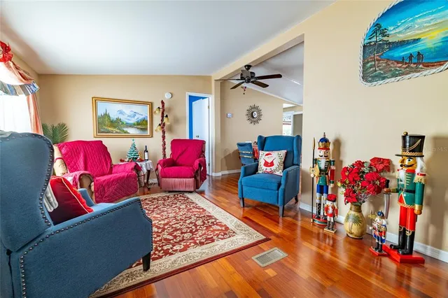 a living room with stainless steel appliances furniture a flat screen tv and kitchen view