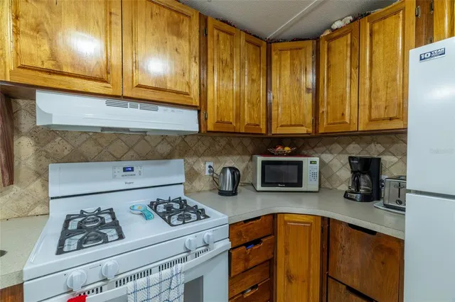 a kitchen with stainless steel appliances granite countertop a refrigerator sink and cabinets