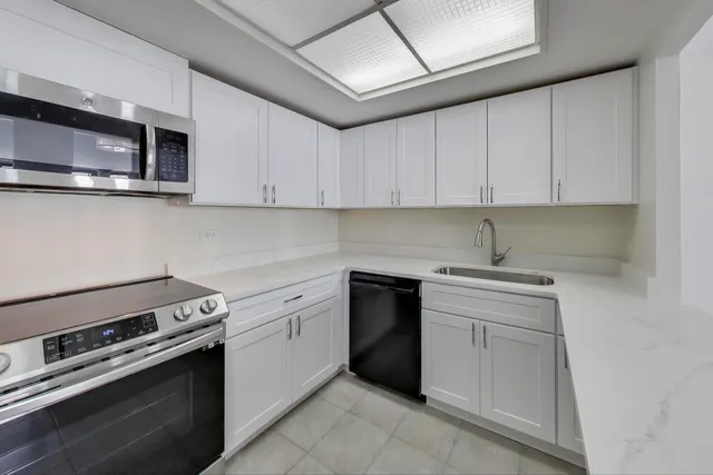 a kitchen with white cabinets and stainless steel appliances