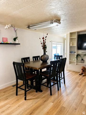 33 Apollo Way Sandy, UT 84070 - Photo 5 of 9 Dining room with a textured ceiling, light wood-type flooring, and built in features