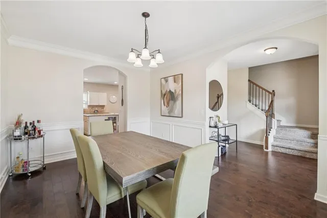 a view of a dining room with furniture a chandelier and wooden floor