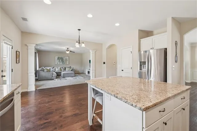 a kitchen with kitchen island a counter top space a sink stainless steel appliances and cabinets
