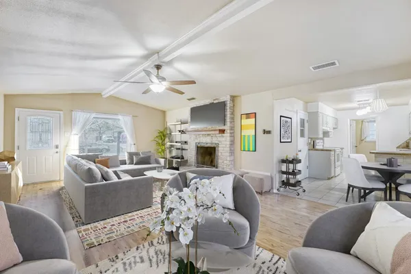a living room with furniture a fireplace and a chandelier