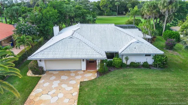 an aerial view of residential houses with outdoor space and trees
