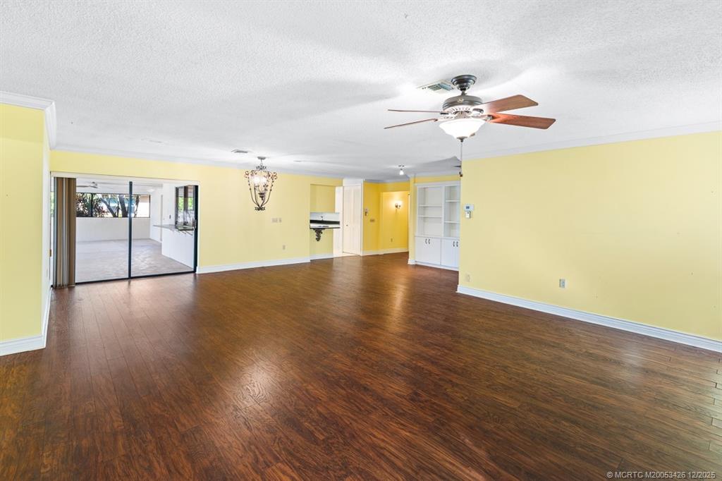 3181 Southeast Fairway West Stuart, FL 34997 - Photo 24 of 64 a view of a room with wooden floor a ceiling fan and window