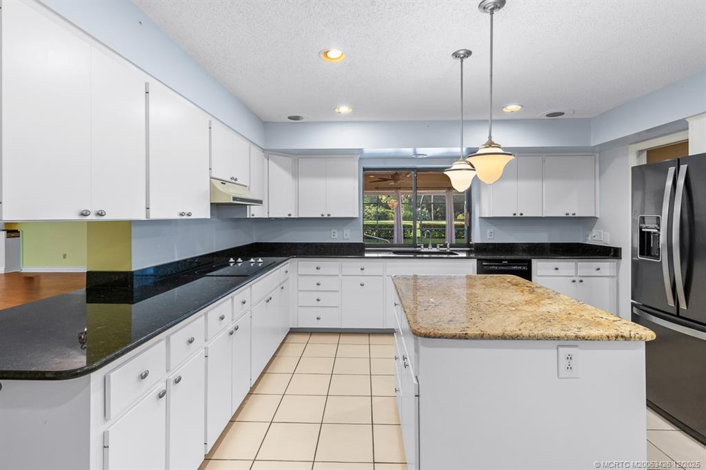 3181 Southeast Fairway West Stuart, FL 34997 - Photo 29 of 64 a kitchen with stainless steel appliances granite countertop a sink a stove counter space and cabinets