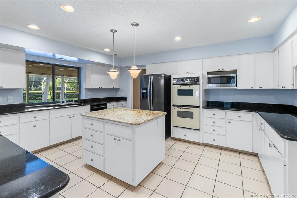 3181 Southeast Fairway West Stuart, FL 34997 - Photo 31 of 64 a kitchen with stainless steel appliances a stove sink and microwave