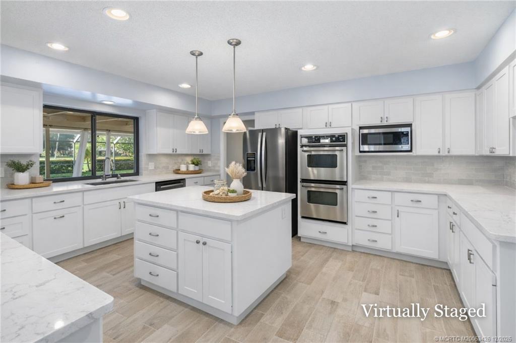 3181 Southeast Fairway West Stuart, FL 34997 - Photo 32 of 64 a kitchen with a stove a sink and a refrigerator