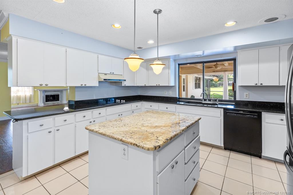 3181 Southeast Fairway West Stuart, FL 34997 - Photo 33 of 64 a kitchen with granite countertop a sink and white cabinets