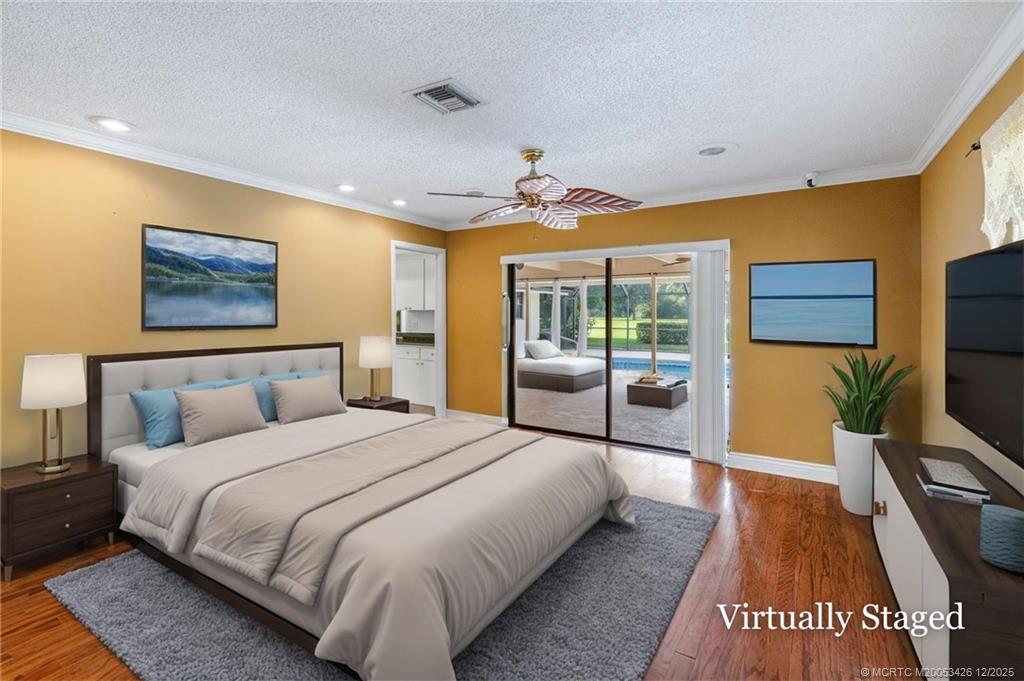 3181 Southeast Fairway West Stuart, FL 34997 - Photo 36 of 64 a spacious bedroom with a bed and a flat screen tv