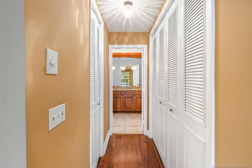 3181 Southeast Fairway West Stuart, FL 34997 - Photo 39 of 64 a view of a hallway with wooden floor and a bathroom