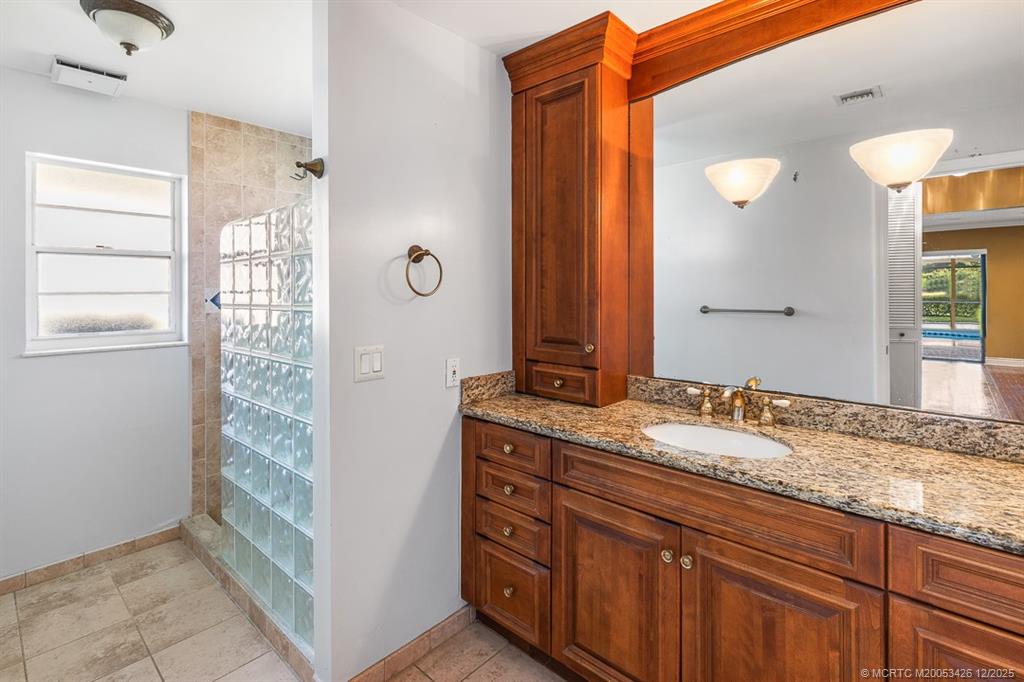 3181 Southeast Fairway West Stuart, FL 34997 - Photo 40 of 64 a bathroom with a granite countertop sink and a mirror