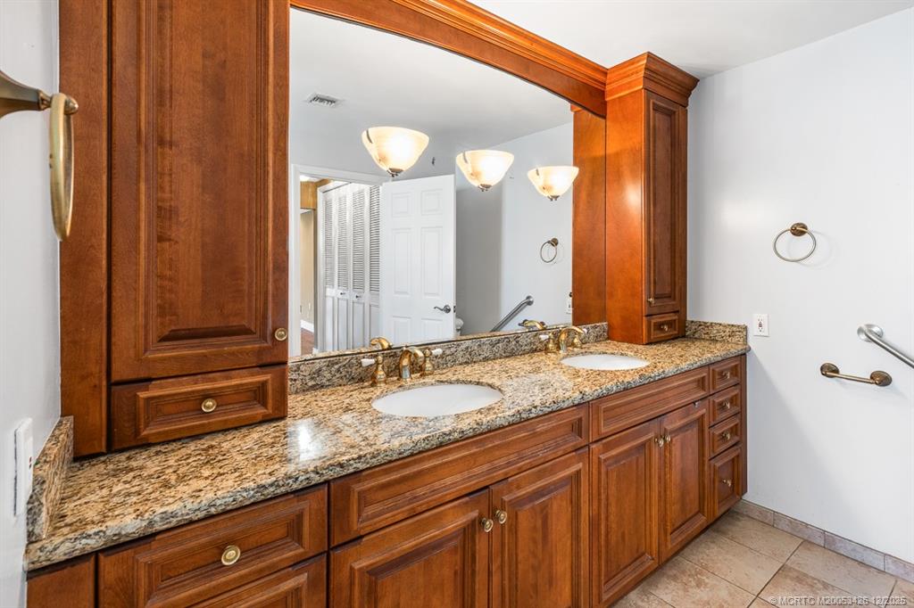 3181 Southeast Fairway West Stuart, FL 34997 - Photo 41 of 64 a bathroom with a granite countertop double vanity sink and a mirror