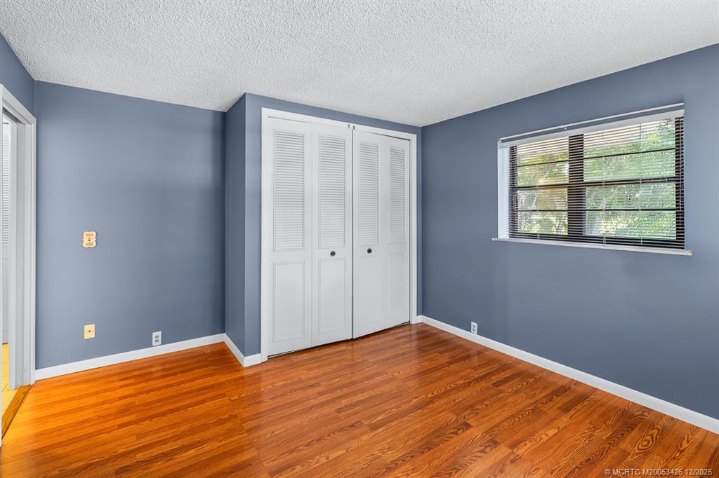 3181 Southeast Fairway West Stuart, FL 34997 - Photo 49 of 64 a view of an empty room with wooden floor and a window