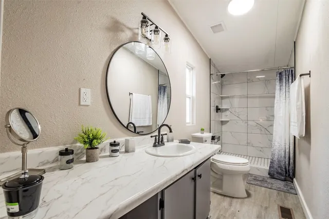 a bathroom with a sink toilet and shower