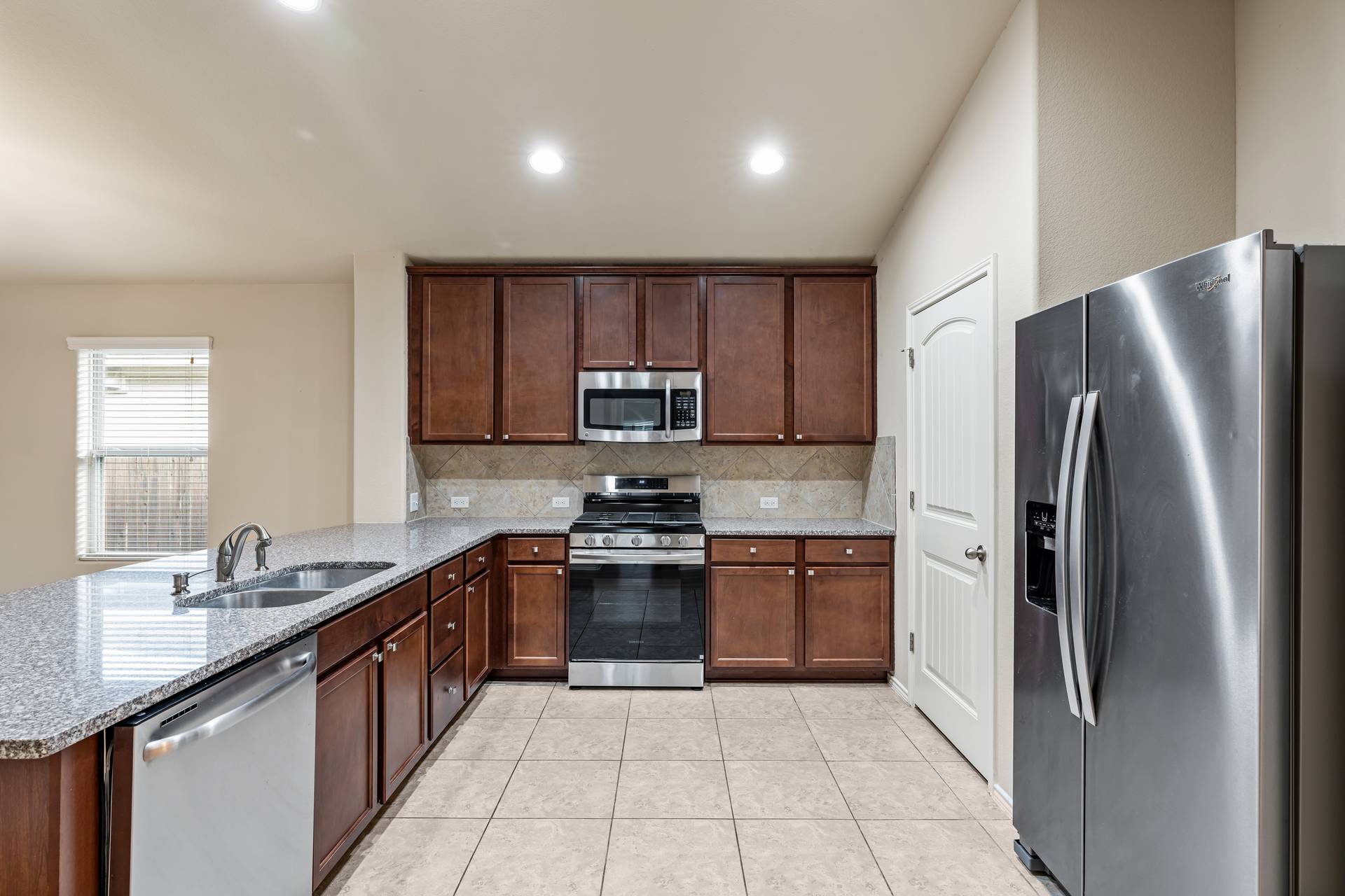 180 Fletcher Bend Buda, TX 78610 - Photo 9 of 36 a kitchen with stainless steel appliances granite countertop a refrigerator sink and stove