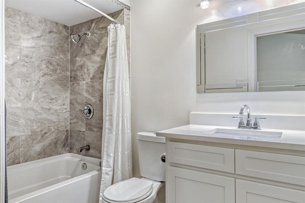8750 Park Lane, Unit 142 Dallas, TX 75231 - Photo 12 of 17 Bathroom featuring vanity and shower / tub combo with curtain