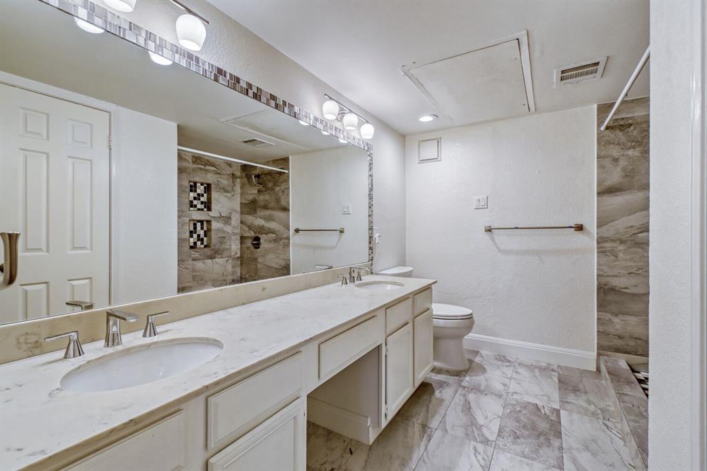 8750 Park Lane, Unit 142 Dallas, TX 75231 - Photo 13 of 17 Full bath featuring double vanity, tiled shower, and a textured wall