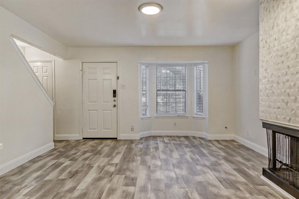 8750 Park Lane, Unit 142 Dallas, TX 75231 - Photo 4 of 17 Foyer featuring light wood-style flooring and a fireplace