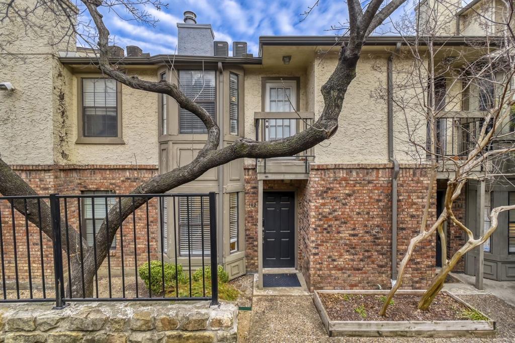 8750 Park Lane, Unit 142 Dallas, TX 75231 - Photo 7 of 17 View of front of house with brick siding, stucco siding, and a chimney