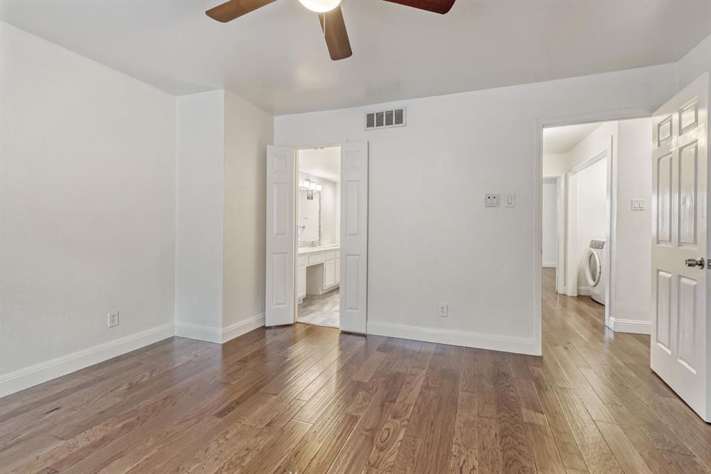 8750 Park Lane, Unit 142 Dallas, TX 75231 - Photo 10 of 17 Upstairs is uniform wood flooring with ensuite bath, ceiling fan, and independent washer and dryer on the 2nd floor