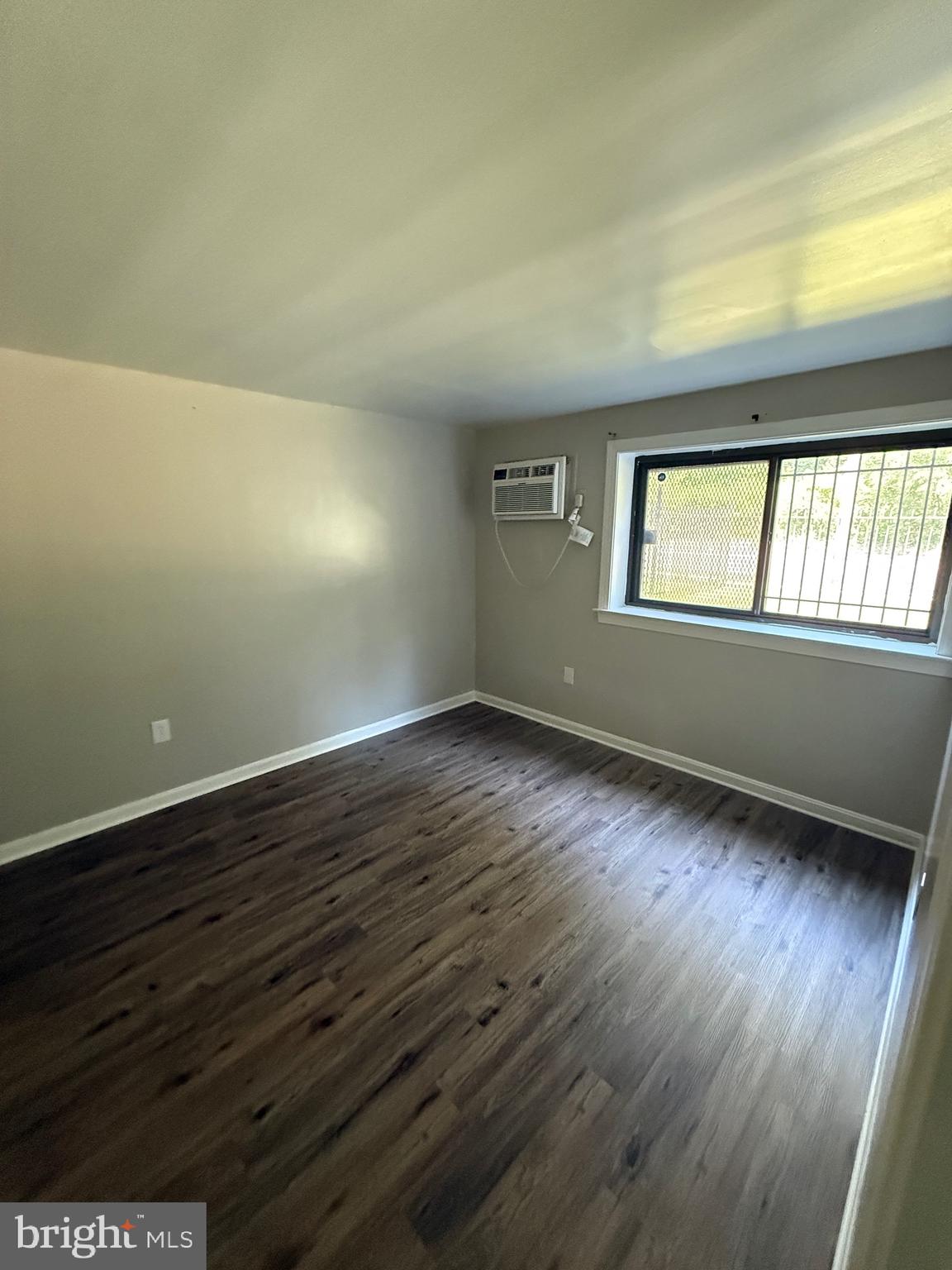 3105 Naylor Road Southeast, Unit 104 Washington, DC 20020 - Photo 7 of 12 an empty room with wooden floor and windows