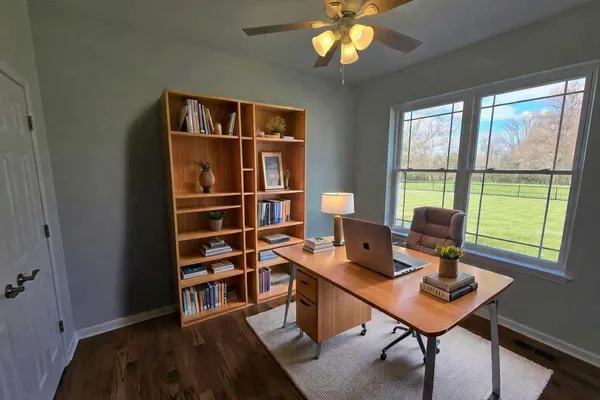 a view of a workspace with furniture and a window