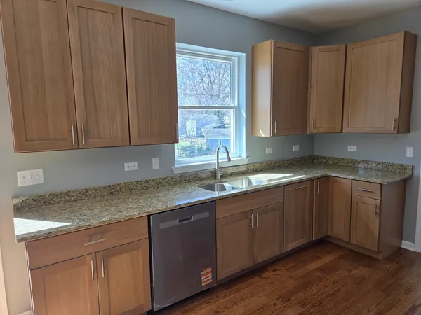a kitchen with stainless steel appliances granite countertop wooden cabinets a sink and dishwasher