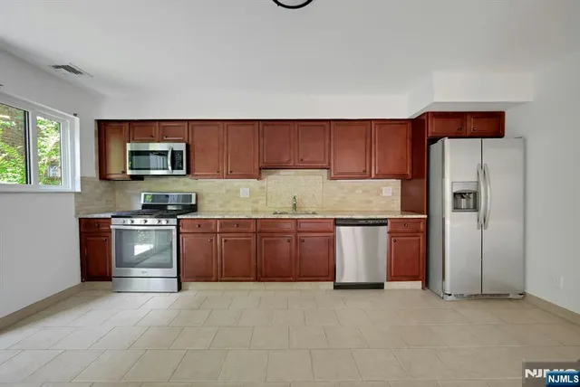 a kitchen with stainless steel appliances granite countertop a refrigerator sink and cabinets