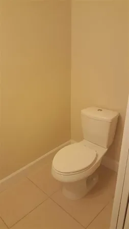 a white toilet sitting next to a white wall