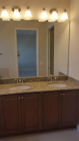 a bathroom with a granite countertop sink and mirror