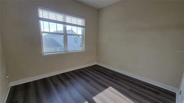 wooden floor in an empty room with a window