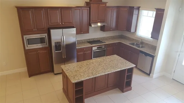 a kitchen with stainless steel appliances granite countertop a refrigerator stove and sink
