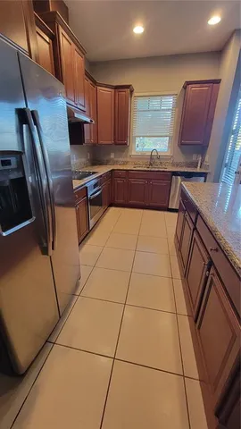 a kitchen with stainless steel appliances a stove a sink a microwave and a refrigerator