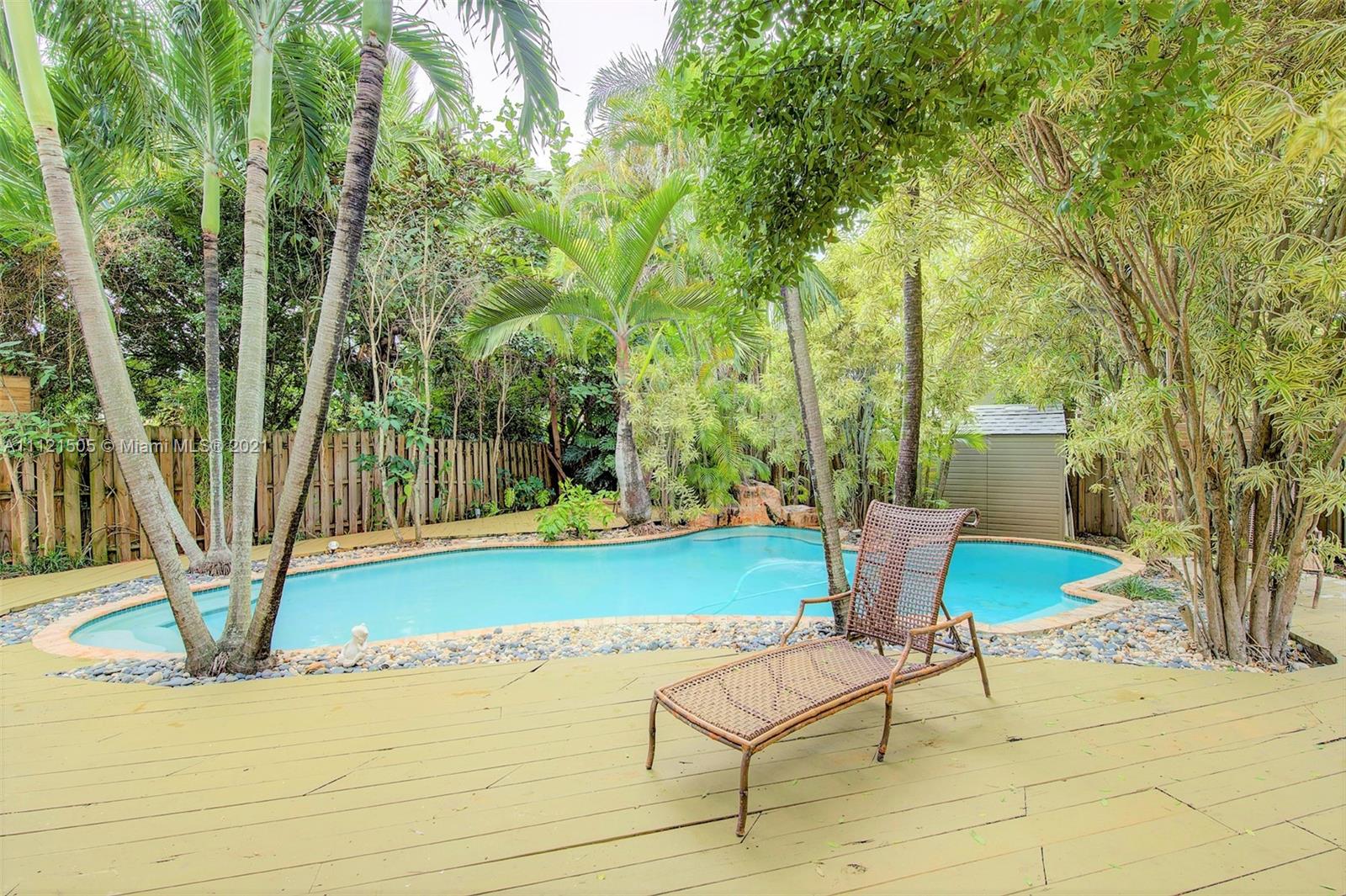 331 Southwest 19th Road Miami, FL 33129 - Photo 20 of 22 a view of a backyard with table and chairs potted plants and large tree