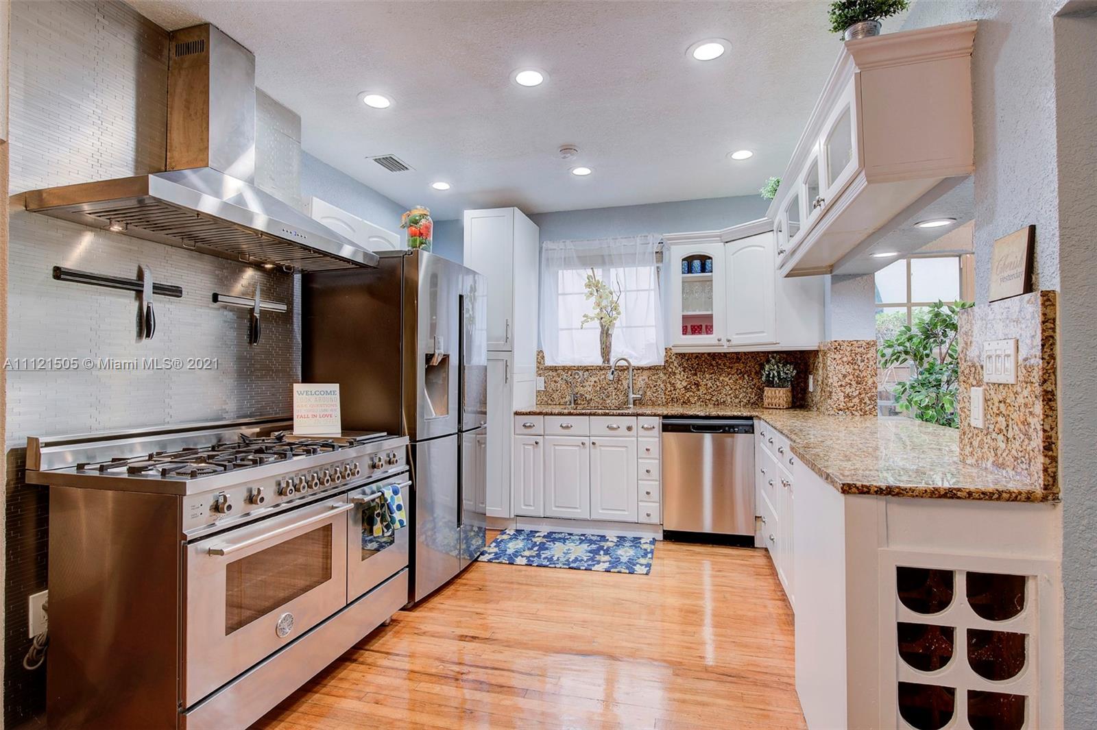 331 Southwest 19th Road Miami, FL 33129 - Photo 8 of 22 a kitchen with granite countertop kitchen island stainless steel appliances a stove a sink and a refrigerator