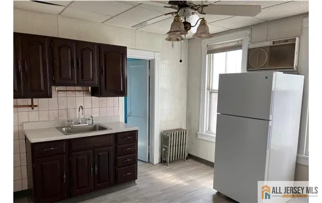 a kitchen with a refrigerator a sink and dishwasher with wooden floor