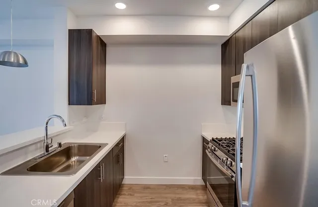 a kitchen with stainless steel appliances granite countertop a sink stove and refrigerator