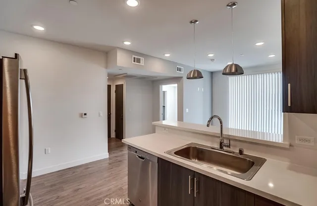 a kitchen with granite countertop a sink and a refrigerator