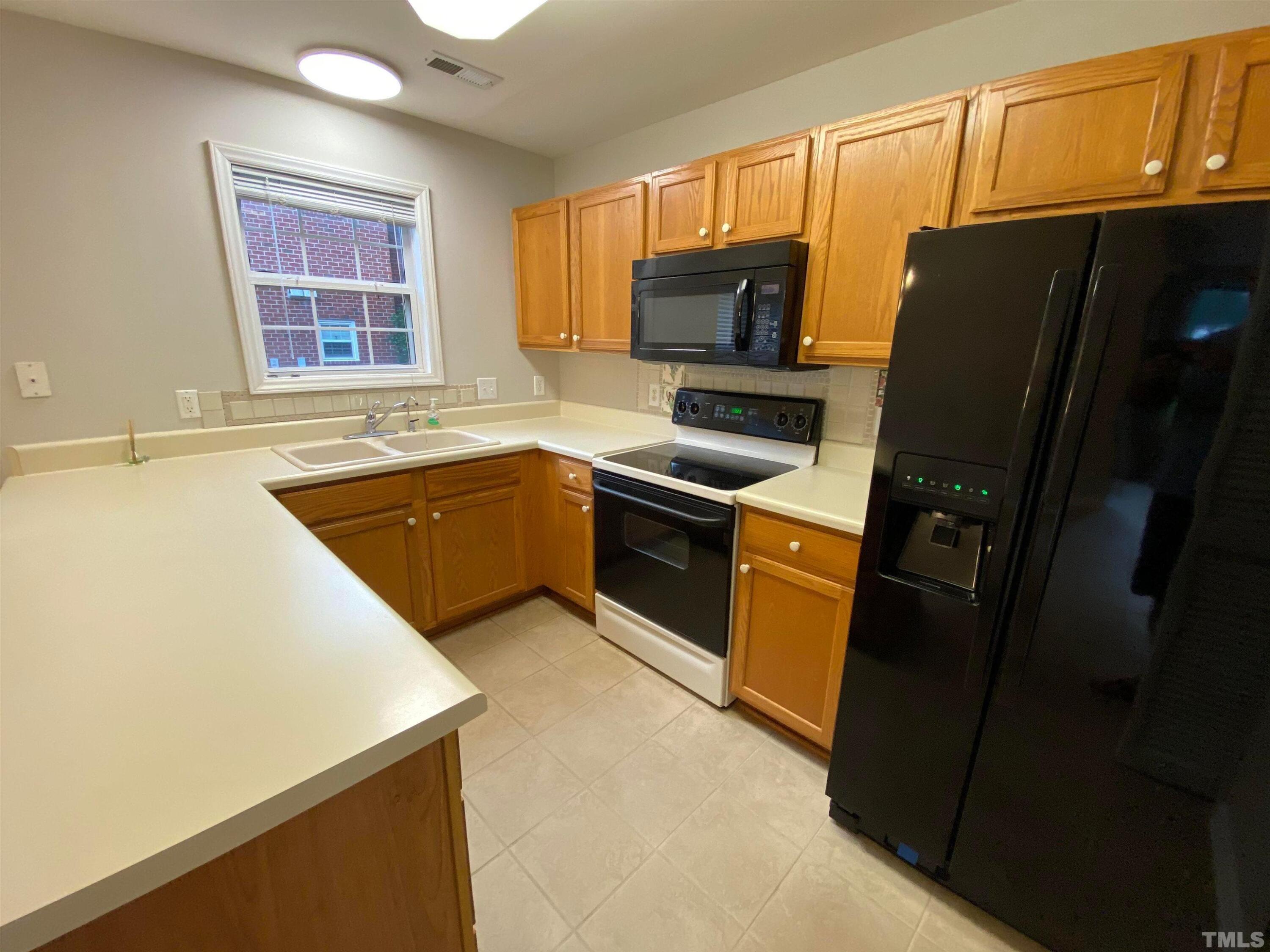 2413 Wellington Ridge Loop, Unit 2413 Cary, NC 27518 - Photo 13 of 30 a kitchen with a refrigerator stove and microwave