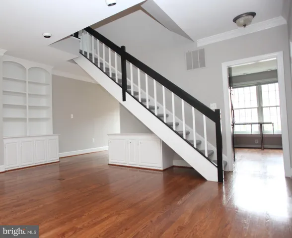 a view of staircase with wooden floor and white walls