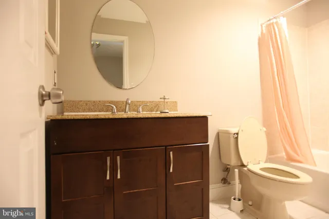 a bathroom with a sink vanity mirror and toilet
