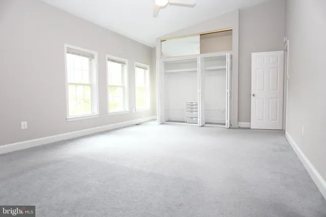 an empty room with windows and closet