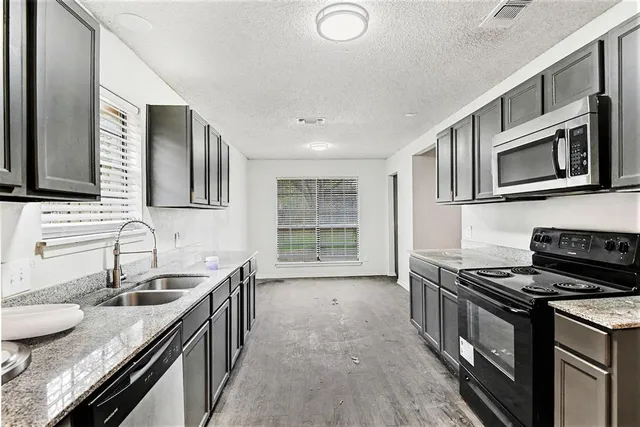 a kitchen with stainless steel appliances granite countertop a stove and a microwave