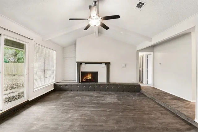 a view of empty room with fireplace and fan